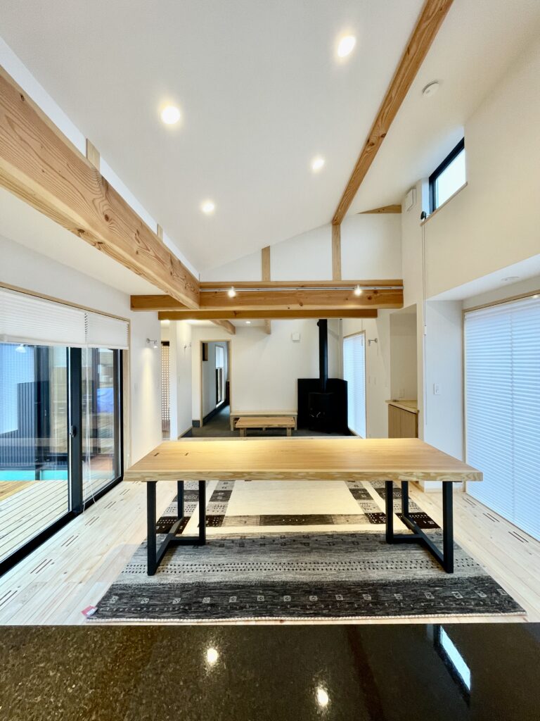 山梨県八ヶ岳南麓北杜市長坂町に建築したソーラーシステムそよ風で床暖房するパッシブデザインの平家の自然素材の家 木の塀で目隠ししたアウトドアリビングのウッドデッキの中庭でプライベートスペースとリビングをゾーン分けしたコの字型の間取り設計プラン インテリアは消臭調湿効果が高い珪藻土や無垢の木など天然素材仕上げ 夏や梅雨時は湿気や熱を排気し冬は太陽で温めた外気を床下に送り換気をしながら床暖房するソーラーシステムそよ風と玄関続きの土間に設置した薪ストーブで家中足元から暖かくします 自然素材とソーラーシステムそよ風の相乗効果で湿気が少なく夏涼しく冬暖かい明るく風通しのいいサステナブルな環境共生住宅です ウォークスルーシューズクローク ロフトがあるファミリーウォークインクローゼット 造作収納家具 御影石天板造作キッチン 御影石天板の造作洗面化粧台 ロフト パントリー 書斎 ホームオフィスなどあったらいいねがある家です 木のゲートや目隠し塀でプライバシーに配慮 家の中も外もグランピング気分楽しめる設計プランです