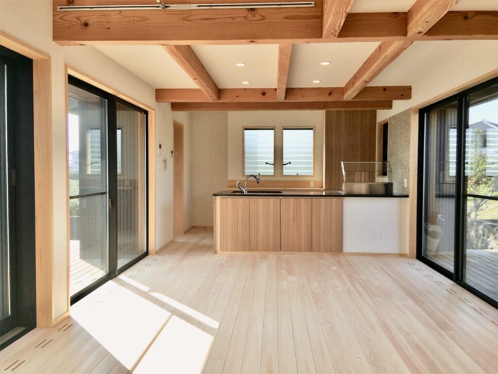 裾野市御宿に建築したソーラーシステムそよ風で床暖房するパッシブデザインのサステナブルな自然素材の家 画像はウッドデッキの中庭とウッドデッキのバックヤードが隣接する吹抜けのリビング