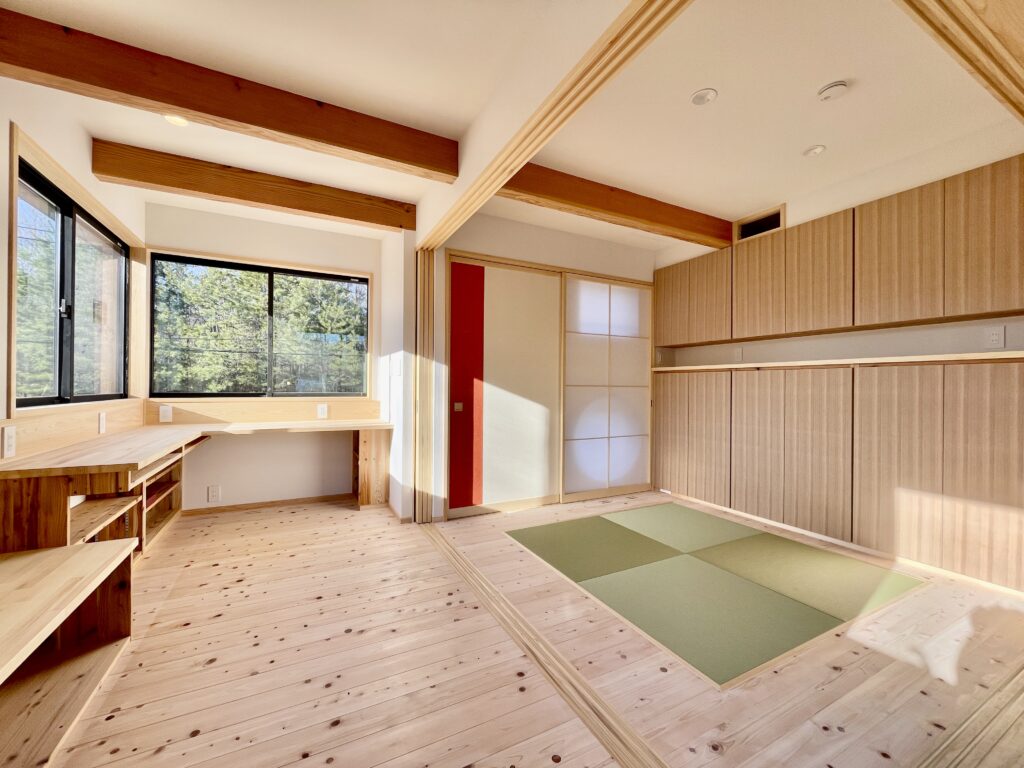 [山梨県八ヶ岳南麓北杜市長坂に建築したパッシブデザインの自然素材の家　建築設計施工事例]自然素材の家　別荘　注文住宅専門の建築設計事務所と建てるソーラーシステムそよ風で床暖房するサステナブルな環境共生住宅 コの字型間取りプラン 画像は玄関土間から続くホームオフィス L型のカウンターテーブルや打ち合わせ用のベンチなど収納家具は造り付けで作成 引き込み式の障子を閉めると客間になります