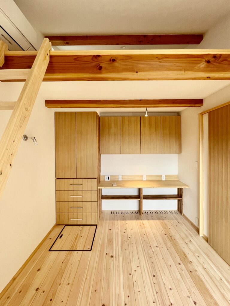 神奈川県鎌倉市西鎌倉に建築したL字型間取り設計の自然素材の家。夏や梅雨時は湿気や熱を排気し、冬は太陽熱で温めた外気を床下に送り換気をしながら床暖房するソーラーシステムそよ風で家中足元から暖かくします。壁天井は消臭調湿効果が高い珪藻土、床は桧フローリングなど天然素材仕上げ。自然素材とソーラーシステムそよ風の相乗効果で湿気が少なく夏涼しく冬暖かいパッシブデザインの環境共生住宅です。 全室収納は造り付けで作成したのでスッキリものが片付き使い勝手と住み心地がいいサステナブルハウス。 画像はロフトがあるホームオフィス。カウンター机や本棚、クローゼットを造り付けで作成。テレワーク・リモートワークなど在宅勤務でもストレスなく仕事がこなせます。