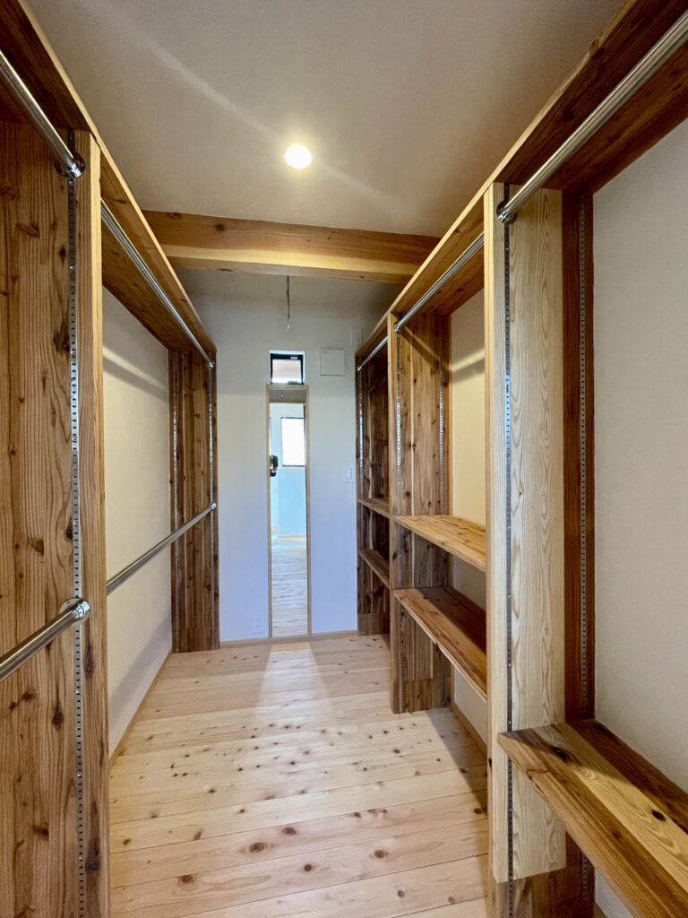 神奈川県鎌倉市西鎌倉に建築したL字型間取り設計の自然素材の家。夏や梅雨時は湿気や熱を排気し、冬は太陽熱で温めた外気を床下に送り換気をしながら床暖房するソーラーシステムそよ風で家中足元から暖かくします。壁天井は消臭調湿効果が高い珪藻土、床は桧フローリングなど天然素材仕上げ。自然素材とソーラーシステムそよ風の相乗効果で湿気が少なく夏涼しく冬暖かいパッシブデザインの環境共生住宅です。 全室収納は造り付けで作成したのでスッキリものが片付き使い勝手と住み心地がいいサステナブルハウス。 画像はファミリーウォークインクローゼット。