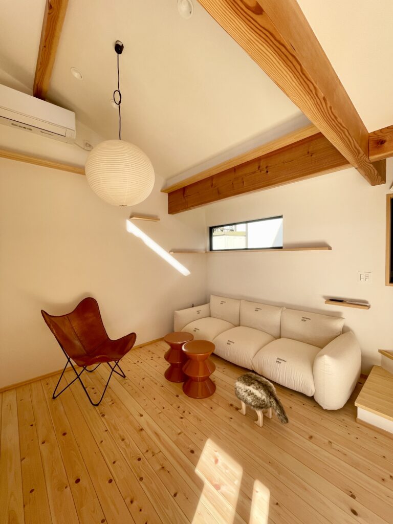 神奈川県鎌倉市西鎌倉に建築したL字型間取り設計の自然素材の家。夏や梅雨時は湿気や熱を排気し、冬は太陽熱で温めた外気を床下に送り換気をしながら床暖房するソーラーシステムそよ風で家中足元から暖かくします。壁天井は消臭調湿効果が高い珪藻土、床は桧フローリングなど天然素材仕上げ。自然素材とソーラーシステムそよ風の相乗効果で湿気が少なく夏涼しく冬暖かいパッシブデザインの環境共生住宅です。 全室収納は造り付けで作成したのでスッキリものが片付き使い勝手と住み心地がいいサステナブルハウス。 画像は猫階段やキャットウォークがあり猫も人も楽しい吹抜けのリビング。アルフレックスのマリオマレンコソファーやバタフライチェアーなどお気に入れの家具でコーディネート。