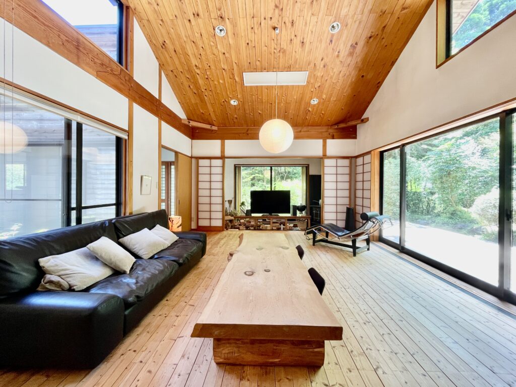 静岡県東部裾野市富士急十里木高原別荘地に建築したソーラーシステムで床暖房するパッシブデザインの自然素材の家 壁天井は消臭調湿効果が高い珪藻土、床は無垢の桧フローリングなど全室天然素材仕上げ 夏や梅雨時は湿気や熱を排気し、冬は太陽熱で温めた外気を床下に送り換気をしながら床暖房するソーラーシステムそよ風と玄関続きの土間に設置した薪ストーブで家中足元から暖かくします 自然素材とソーラーシステムそよ風の相乗効果で湿気が少なく夏涼しく冬暖かい環境共生住宅です 画像は玄関続きの土間 苔の中庭 ウッドデッキが隣接する東西南北と高窓からの通風と採光で明るく風通しのいいリビング 杉の無垢一枚物のダイニングテーブル アルフレックスベンゴディソファー 築25年以上経過した自然素材の家がどのように変化するのか、ソーラーシステムなど体感できますのでお問い合わせください