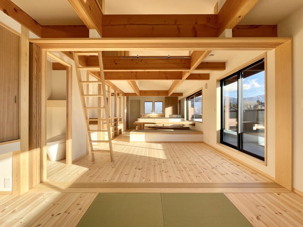 御殿場市に建築したパッシブデザインのサステナブルな自然素材の家。夏や梅雨時は湿気や熱を排気し、冬は太陽熱で温めた外気を床下に送り換気をしながら床暖房するソーラーシステムそよ風で家中暖かくします。 全室壁天井は消臭調湿効果が高い珪藻土、床は無垢の桧フローリングなど天然素材仕上げ。 自然素材とソーラーシステムそよ風の相乗効果で湿気が少なく夏涼しく冬暖かいサステナブルな環境共生住宅です。 趣味のスノーボードのワックス掛けができる広い玄関土間。 子供の成長に合わせ将来造作収納家具で間仕切りできる子供部屋。 温泉気分で入浴できる1.25坪サイズの浴室。 御影石天板の造作キッチンと食器棚を造り付けで作成。 2階吹抜けのリビングに隣接した富士山一望のウッドデッキのルーフバルコニーはアウトドアリビングでグランピング気分が味わえます。 御影石天板の造作キッチンと一体化した畳ベンチ、無垢一枚もののダイニングテーブル、パントリー収納、リビングの家事、リモート・テレワークコーナー、テレビ台、脱衣室収納、造作洗面化粧台、カウンター机など造り付けで収納を作成。 ウォークスルーシューズインクローク、玄関下足入れ、階段下収納、ファミリーウォークインクローゼットなど収納がたくさんあるのでスッキリものが片付き使い勝手がいい2階リビングの注文住宅を新築しました。