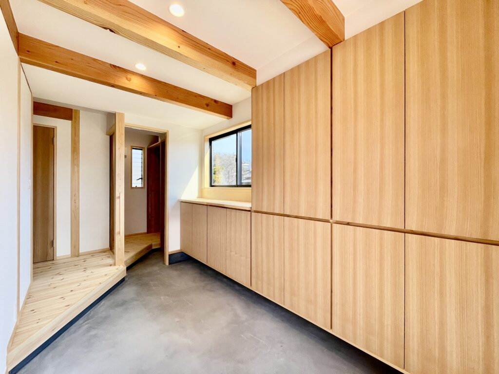 御殿場市に建築したパッシブデザインのサステナブルな自然素材の家。夏や梅雨時は湿気や熱を排気し、冬は太陽熱で温めた外気を床下に送り換気をしながら床暖房するソーラーシステムそよ風で家中暖かくします。 全室壁天井は消臭調湿効果が高い珪藻土、床は無垢の桧フローリングなど天然素材仕上げ。 自然素材とソーラーシステムそよ風の相乗効果で湿気が少なく夏涼しく冬暖かいサステナブルな環境共生住宅です。 趣味のスノーボードのワックス掛けができる広い玄関土間。 子供の成長に合わせ将来造作収納家具で間仕切りできる子供部屋。 温泉気分で入浴できる1.25坪サイズの浴室。 御影石天板の造作キッチンと食器棚を造り付けで作成。 2階吹抜けのリビングに隣接した富士山一望のウッドデッキのルーフバルコニーはアウトドアリビングでグランピング気分が味わえます。 御影石天板の造作キッチンと一体化した畳ベンチ、無垢一枚もののダイニングテーブル、パントリー収納、リビングの家事、リモート・テレワークコーナー、テレビ台、脱衣室収納、造作洗面化粧台、カウンター机など造り付けで収納を作成。 ウォークスルーシューズインクローク、玄関下足入れ、階段下収納、ファミリーウォークインクローゼットなど収納がたくさんあるのでスッキリものが片付き使い勝手がいい2階リビングの注文住宅を新築しました。