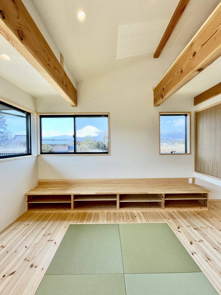 御殿場市に建築したパッシブデザインのサステナブルな自然素材の家。夏や梅雨時は湿気や熱を排気し、冬は太陽熱で温めた外気を床下に送り換気をしながら床暖房するソーラーシステムそよ風で家中暖かくします。 全室壁天井は消臭調湿効果が高い珪藻土、床は無垢の桧フローリングなど天然素材仕上げ。 自然素材とソーラーシステムそよ風の相乗効果で湿気が少なく夏涼しく冬暖かいサステナブルな環境共生住宅です。 趣味のスノーボードのワックス掛けができる広い玄関土間。 子供の成長に合わせ将来造作収納家具で間仕切りできる子供部屋。 温泉気分で入浴できる1.25坪サイズの浴室。 御影石天板の造作キッチンと食器棚を造り付けで作成。 2階吹抜けのリビングに隣接した富士山一望のウッドデッキのルーフバルコニーはアウトドアリビングでグランピング気分が味わえます。 御影石天板の造作キッチンと一体化した畳ベンチ、無垢一枚もののダイニングテーブル、パントリー収納、リビングの家事、リモート・テレワークコーナー、テレビ台、脱衣室収納、造作洗面化粧台、カウンター机など造り付けで収納を作成。 ウォークスルーシューズインクローク、玄関下足入れ、階段下収納、ファミリーウォークインクローゼットなど収納がたくさんあるのでスッキリものが片付き使い勝手がいい2階リビングの注文住宅を新築しました。