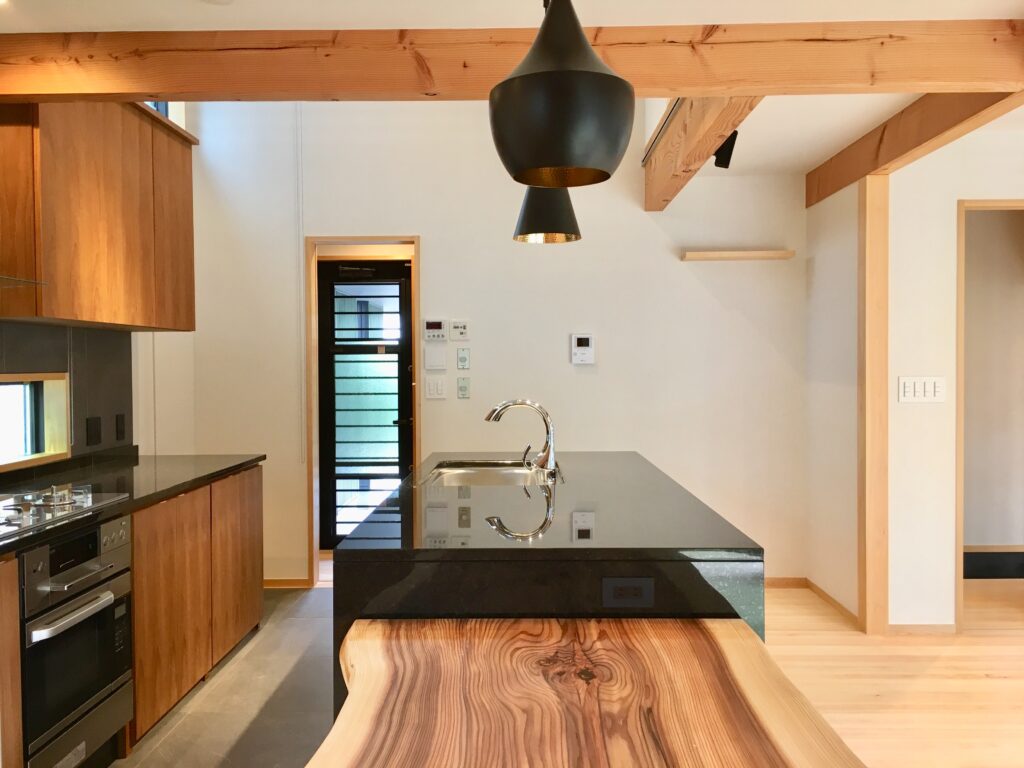 裾野市に建築した2台分のガレージ、ウッドデッキの中庭でプライベートスペースとリビングをゾーン分けした間取りプランの平屋の自然素材の家
画像は御影石天板の造作II列型アイランドキッチン