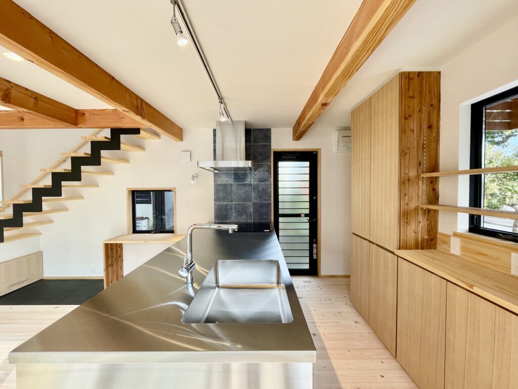 鎌倉市西鎌倉に建築したL字型間取りの自然素材の家 梅雨時や夏は熱気や湿気を排気し冬は太陽熱で温めた外気を床下に送り換気をしながら床暖房するソーラーシステムそよ風で家中足元から暖かい環境共生住宅です 全室壁天井は消臭調湿効果が高い珪藻土床は桧のフローリングなど天然素材仕上げ 自然素材とソーラーシステムそよ風の相乗効果で湿気が少なく夏涼しく冬暖かい明るく風通しのいいパッシブデザインの注文住宅 全室収納を造り付けで作成しスッキリものが片付き使い勝手と居心地がいいサステナブルハウス 画像はステンレスオーダーキッチンと造り付けで作成した造作食器棚