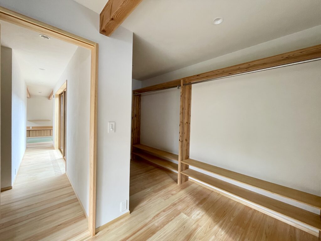 静岡県東部沼津市に建築したコの字型間取りの自然素材の家 。梅雨時や夏は熱気や湿気を排気し冬は太陽熱で温めた外気を床下に送り換気をしながら床暖房するソーラーシステムそよ風で家中足元から暖かい環境共生住宅です。 全室壁天井は消臭調湿効果が高い珪藻土床は桧のフローリングなど天然素材仕上げ 。自然素材とソーラーシステムそよ風の相乗効果で湿気が少なく夏涼しく冬暖かい明るく風通しのいいパッシブデザインの注文住宅 。全室収納を造り付けで作成しスッキリものが片付き使い勝手と居心地がいいサステナブルハウス 。画像は寝室のウォークインクローゼット。カライエで湿気対策。