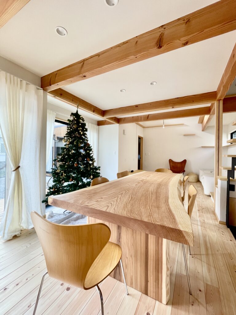 鎌倉市西鎌倉に建築したL字型間取りの自然素材の家 。梅雨時や夏は熱気や湿気を排気し冬は太陽熱で温めた外気を床下に送り換気をしながら床暖房するソーラーシステムそよ風で家中足元から暖かい環境共生住宅です 。全室壁天井は消臭調湿効果が高い珪藻土床は桧のフローリングなど天然素材仕上げ 。自然素材とソーラーシステムそよ風の相乗効果で湿気が少なく夏涼しく冬暖かい明るく風通しのいいパッシブデザインの注文住宅 。全室収納を造り付けで作成しスッキリものが片付き使い勝手と居心地がいいサステナブルハウス。 画像は杉無垢一枚板のテーブルとお気に入りのダイニングチェアー。