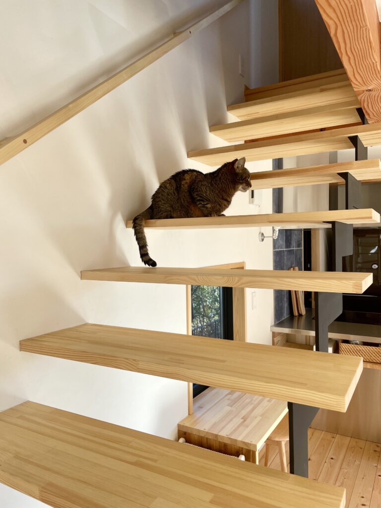 鎌倉市西鎌倉に建築したL字型間取りの自然素材の家 。梅雨時や夏は熱気や湿気を排気し冬は太陽熱で温めた外気を床下に送り換気をしながら床暖房するソーラーシステムそよ風で家中足元から暖かい環境共生住宅です 。全室壁天井は消臭調湿効果が高い珪藻土床は桧のフローリングなど天然素材仕上げ 。自然素材とソーラーシステムそよ風の相乗効果で湿気が少なく夏涼しく冬暖かい明るく風通しのいいパッシブデザインの注文住宅 。全室収納を造り付けで作成しスッキリものが片付き使い勝手と居心地がいいサステナブルハウス。 画像は小さいお子さんから高齢者までゆったり昇降できる勾配が緩い鉄骨のリビング階段。